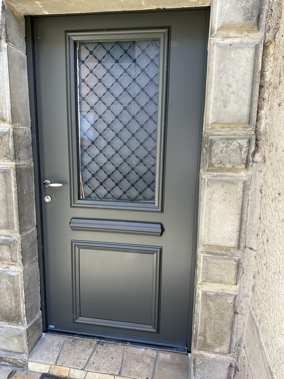 Réalisation VMV Habitat : Porte d'entrée aluminium anthracite avec encadrement en pierre, posée près de Pau (64)