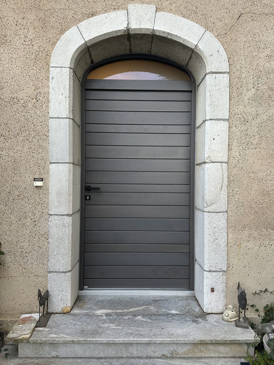 Réalisation VMV Habitat : Porte d'entrée aluminium sous voûte en pierre, posée près de Pau (64)
