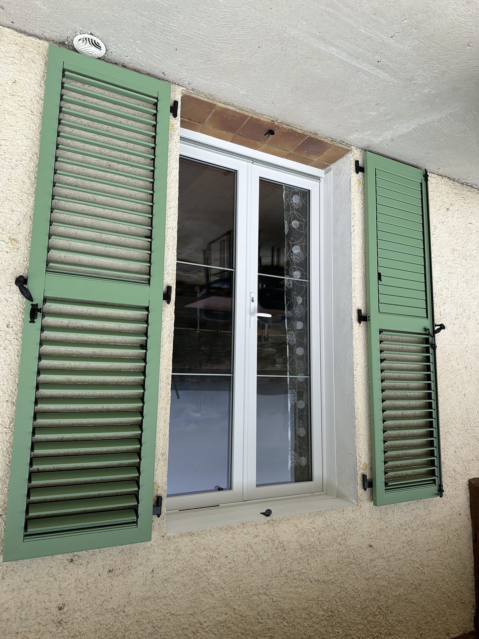 Réalisation VMV Habitat : Fenêtre PVC blanche et volets battants persiennés verts posés près de Pau (64)