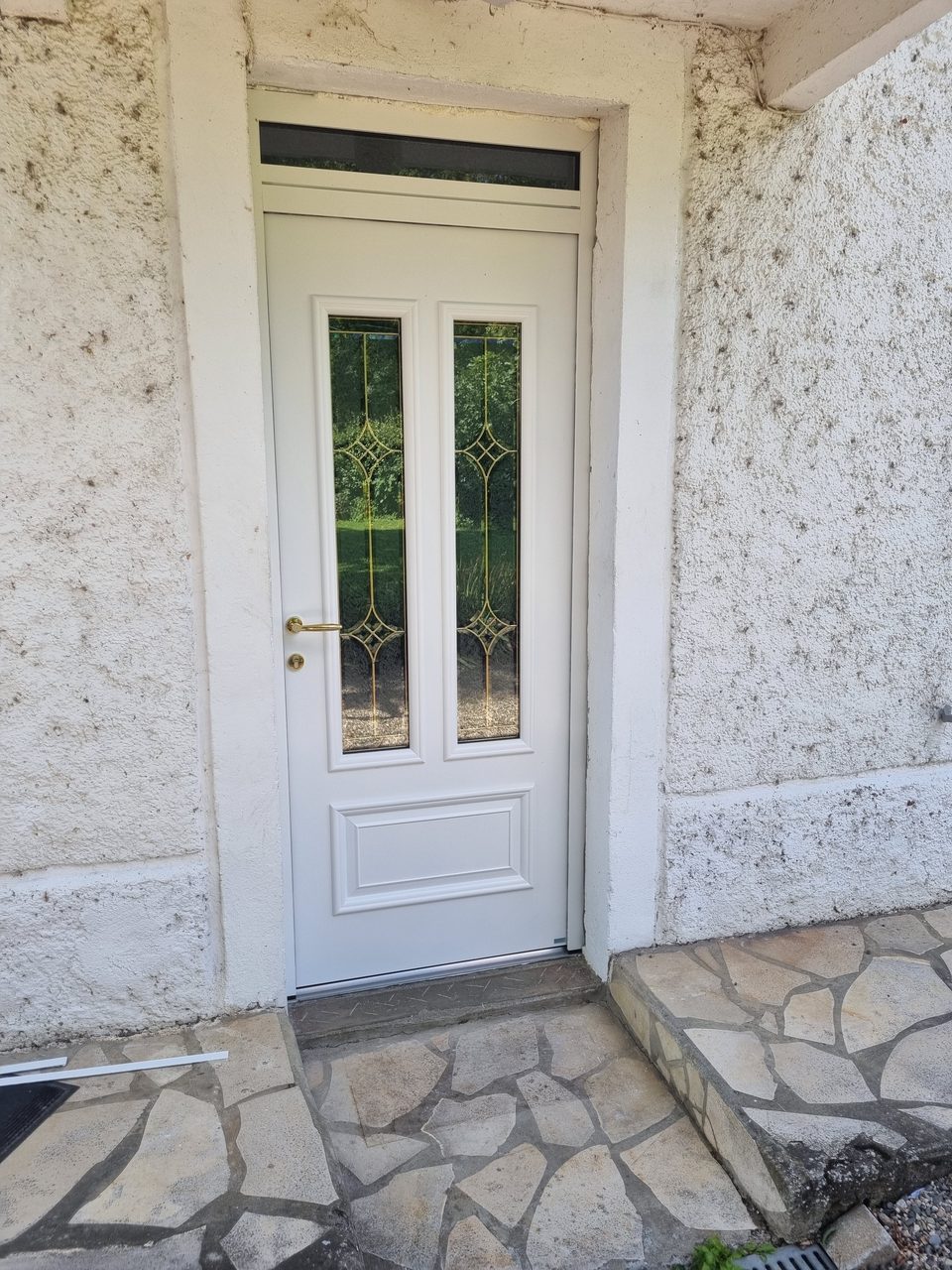 Réalisation VMV Habitat : Porte d'entrée blanche vitrée posée sur façade en pierre près de Pau (64)
